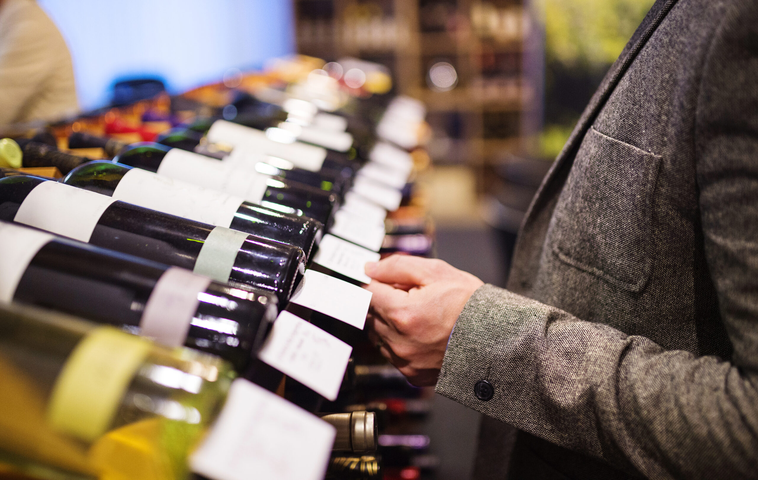 Man in wine shop choosing which wine to purchase