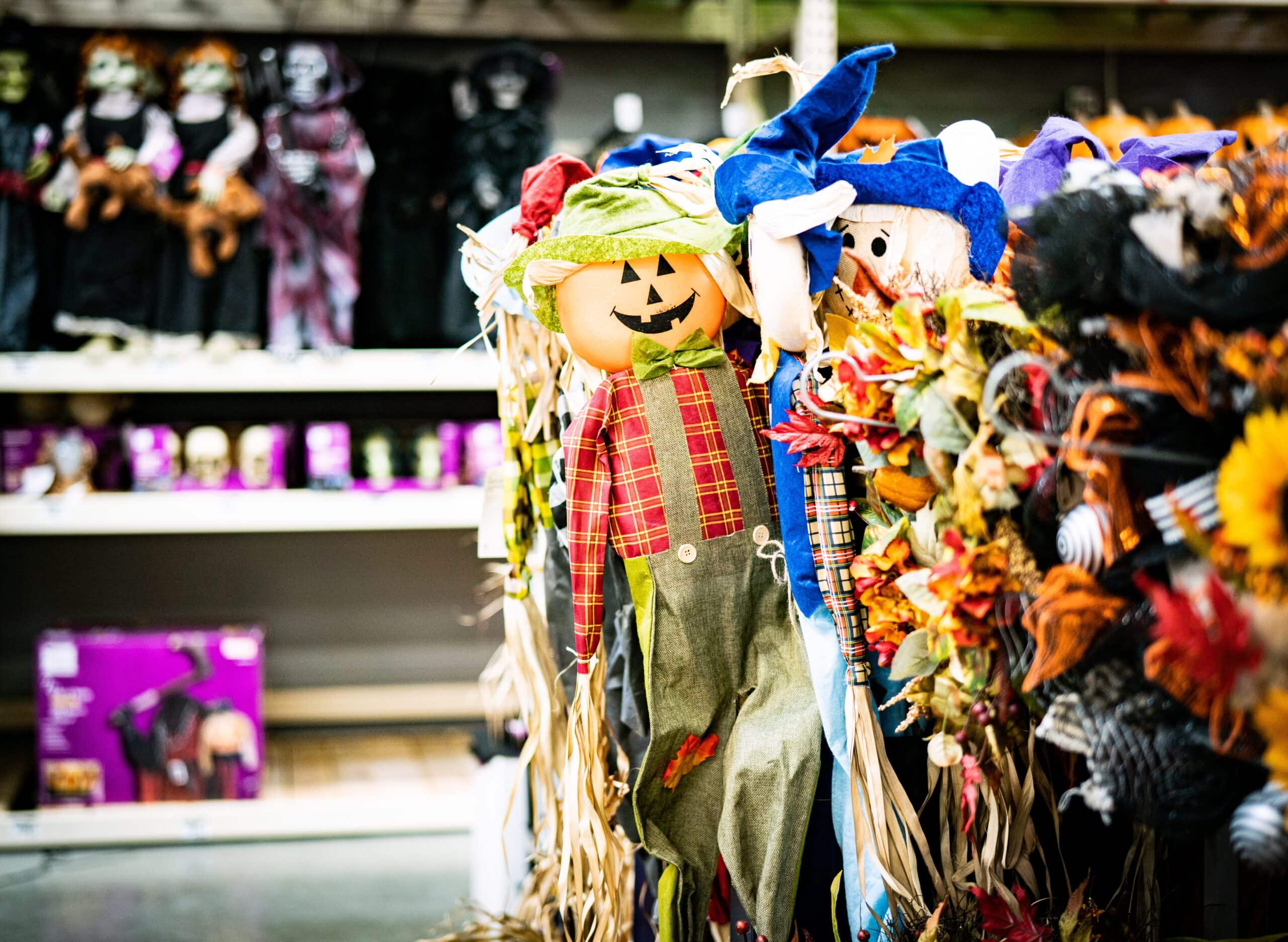 a scarecrow with a pumpkin face and a blue hat