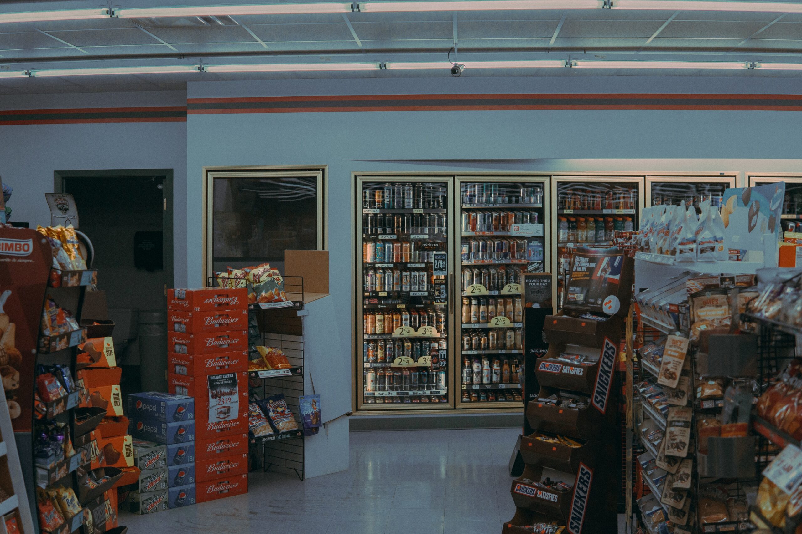 the inside of a convenience store with a display for snickers