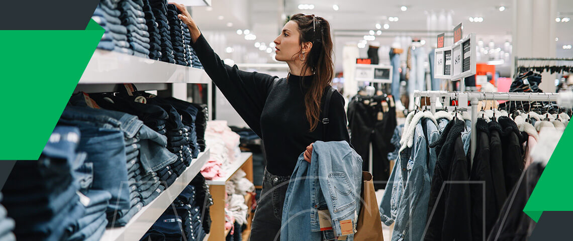 a woman in a black sweater is looking at jeans in a store